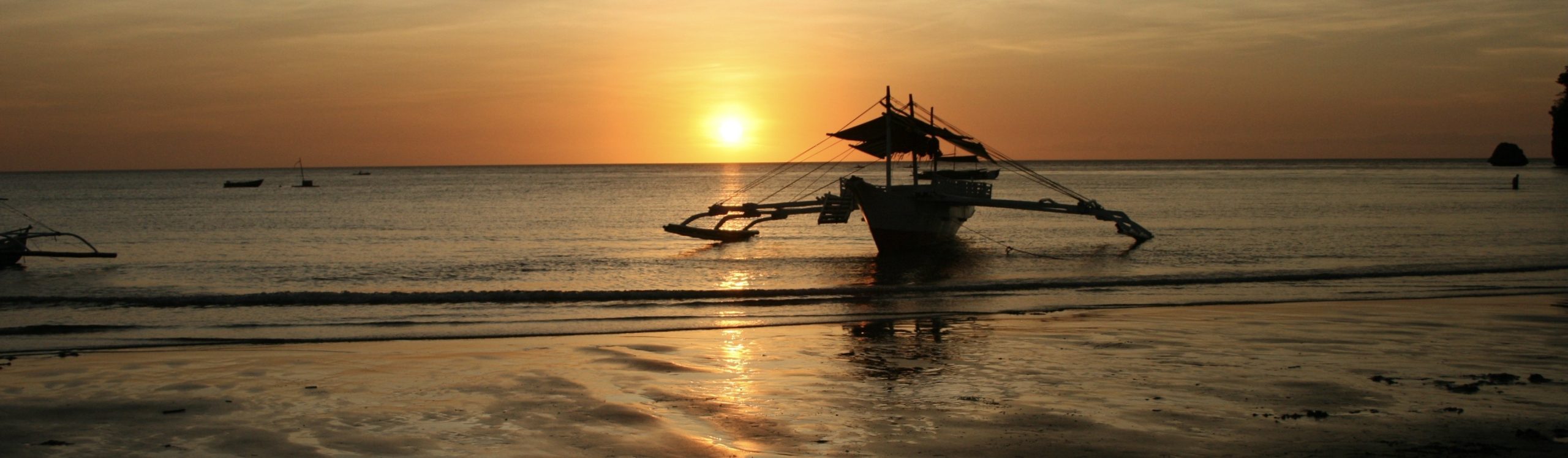 This image shows the sun setting over the sea at Sugar Beach in Sipalay, Negros. The picture shows a traditional philippine fishing boat in the foreground against a background of the verdant orange light emanating from the setting sun. This beach is miles from anywhere that is remotely on the tourist track. This image is included in the post to show the reader that there are some incredible sights to be seen while backpacking in Southeast Asia. The links associated with the photograph provide the reader with information regarding accommodation in Sipalay